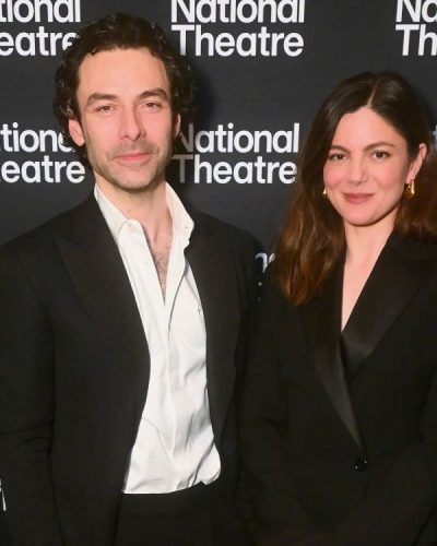 Monica Barbaro in a tailored black blazer and graceful demeanor.