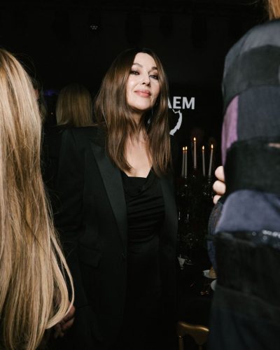 Monica Bellucci in an elegant black dress and clutch.