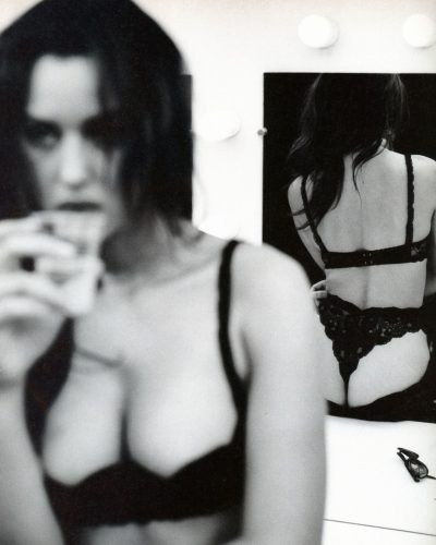 Monica Bellucci wearing delicate white lingerie and flowing sleeves.