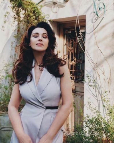 Monica Bellucci in a tailored beige dress with soft tones.