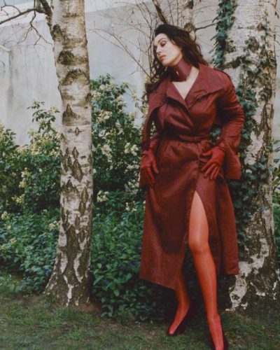 Monica Bellucci wearing a classic beige dress with modern sleeves.