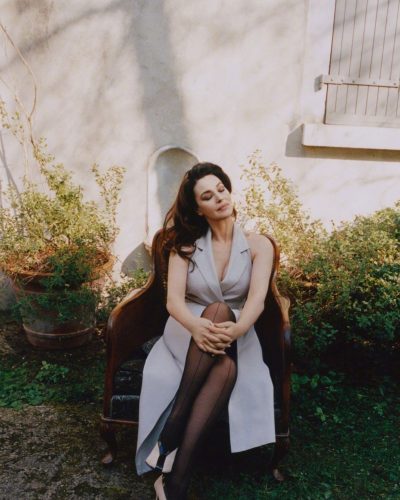 Monica Bellucci in a chic beige dress featuring puffy sleeves.