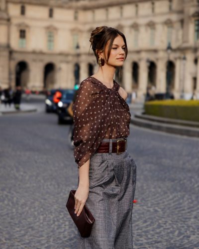 Nadine Leopold in asymmetrical sheer top and chic checkered trousers