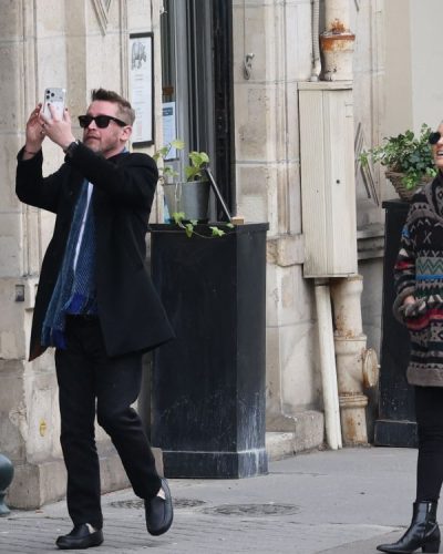 Natalie Portman chic black ankle boots complementing a patterned coat