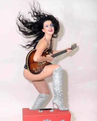 Natasha Blasick in black ensemble with high-shine silver over-the-knee boots.