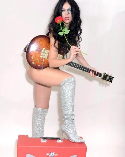 Natasha Blasick in sleek black outfit and reflective silver boots.