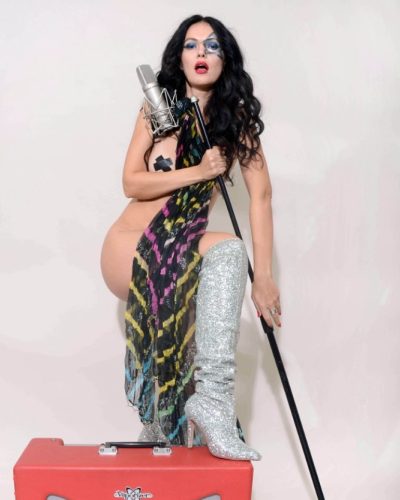 Natasha Blasick dressed in black minimalist piece and metallic silver boots.