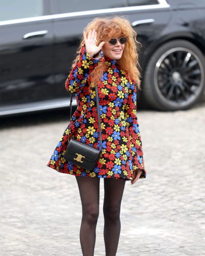 Natasha Lyonne chic crossbody bag with vibrant floral dress