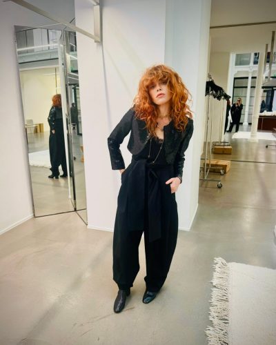 Natasha Lyonne black sleek trousers paired with gold belt