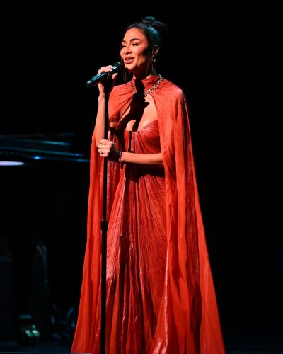 Nicole Scherzinger in a sleek red dress with flowing silhouette