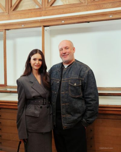 Nina Dobrev wearing stylish wide-brimmed hat and gray coat
