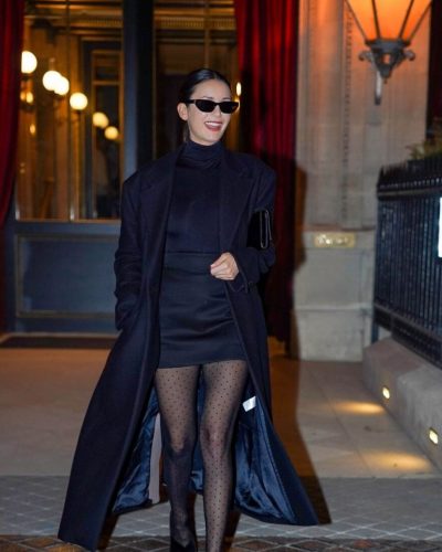 Nina Dobrev black trench coat with playful polka-dot tights