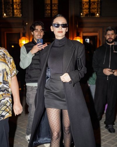 Nina Dobrev monochrome style featuring black trench and tights