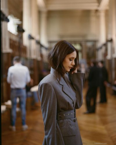 Nina Dobrev in a fitted gray blazer with a modern silhouette.