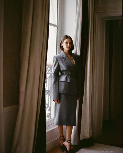 Nina Dobrev in a gray blazer with a sophisticated structured look.