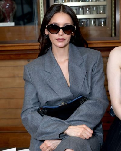Nina Dobrev black handbag adding sophistication to gray ensemble