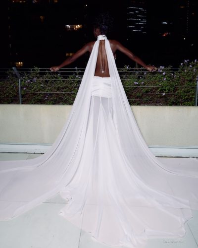 Olandria wearing a fitted red dress against soft lighting