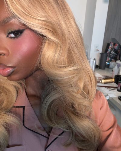 Olandria in a glossy red gown with minimal accessories