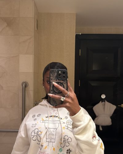 Olandria in a vibrant red latex dress with chic handbag