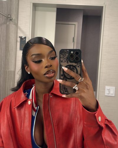 Olandria in a striking red gown paired with small handbag