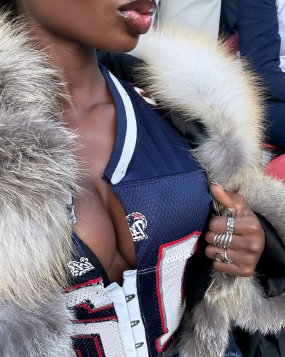 Olandria in a glossy red dress with plunging neckline