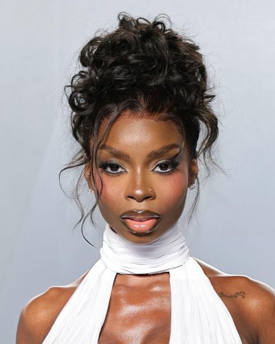 OLANDRIA wearing a white dress with dramatic drapes and cutouts