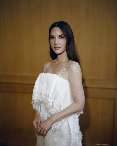 Olivia Munn in a white gown with delicate straps and flowing fabric