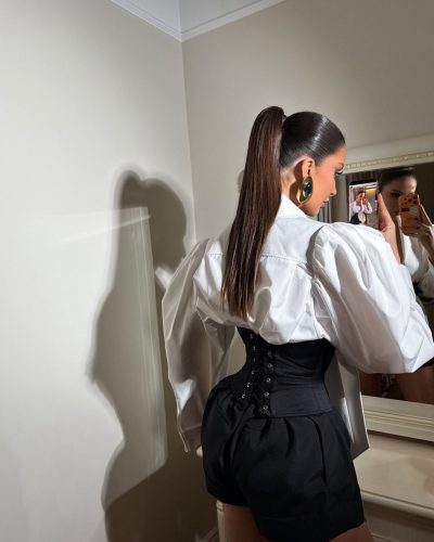 Oriola Marashi in black high-heeled sandals and statement jewelry