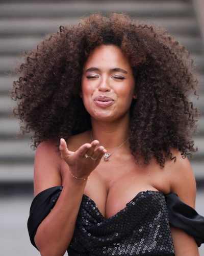 Paola Locatelli in a chic black gown featuring ruffled accents and sequins.