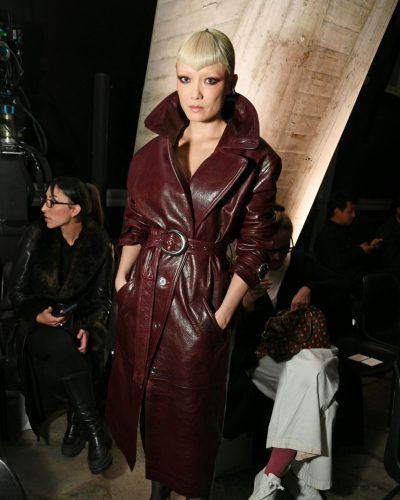 Pom Klementieff wearing thigh-high stockings with burgundy leather coat