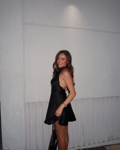 Presley Elise styled in a chic black dress with a unique neckline.