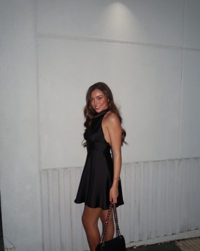 Presley Elise in a sleek black dress with a high neckline design.