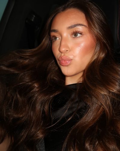 Presley Elise wearing a fitted black dress that flatters her figure.