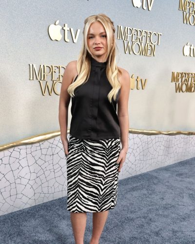 Pressley Hoshbach wearing black sleeveless top paired with striped skirt.