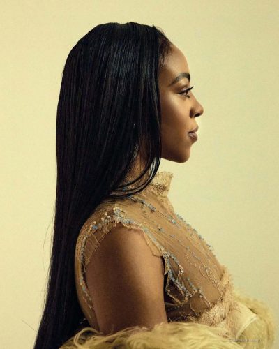 Priah Ferguson in sheer lace top and fluffy outerwear.