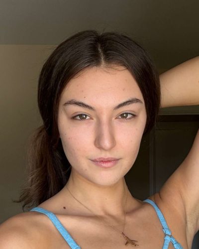 Rachel Pizzolato golden earrings adding flair to beach swimwear