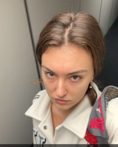 Rachel Pizzolato gray mini dress with sheer sleeves and black boots