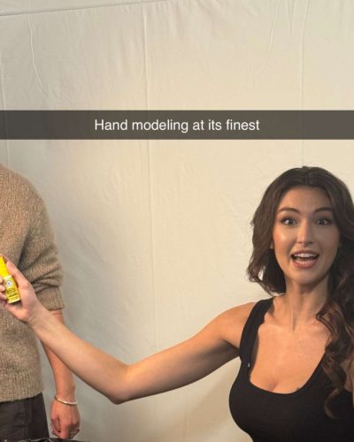 Rachel Pizzolato knee-high black boots complementing her gray mini dress