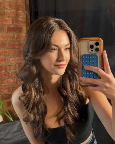 Rachel Pizzolato trendy gray mini dress with bold red accent pillow