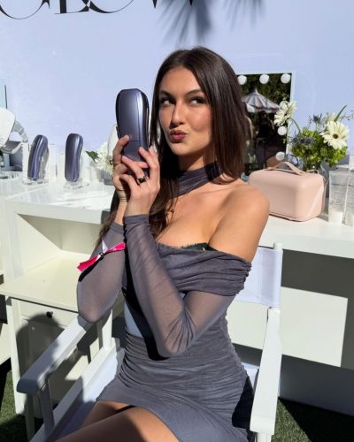 Rachel Pizzolato gray mini dress and playful red pillow in hand