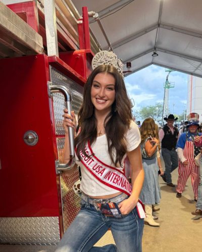 Rachel Pizzolato trendy gray mini dress with bold red accent pillow