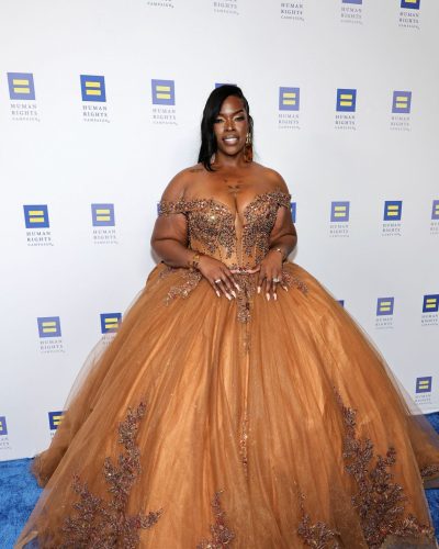 Raeshanda Lias warm smile with off-the-shoulder gown