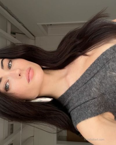 Renee Murden in yellow bikini relaxing on the beach sand.