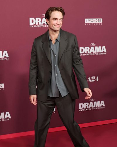 Robert Pattinson in a smart black suit and soft blue button-up.