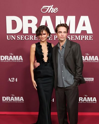 Robert Pattinson in a sleek black suit with a blue shirt.