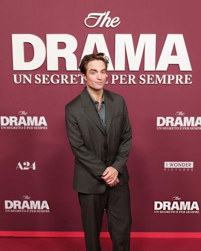 Robert Pattinson dressed in a sophisticated dark suit and light shirt.