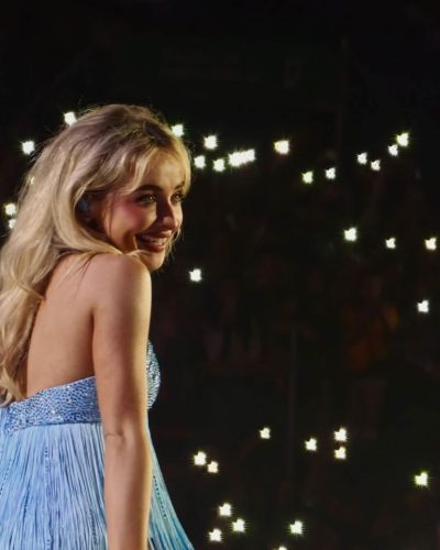 Sabrina Carpenter wearing fitted blue gown with playful cutouts.