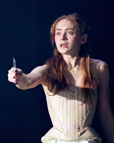 Sadie Sink in a light corset and intricate satin shorts