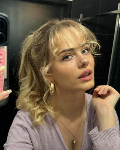 Sara Crumbleleg with brown handbag adding to beige trench coat.