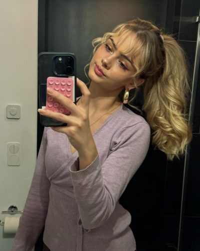 Sara Crumbleleg with brown handbag complementing beige trench coat.